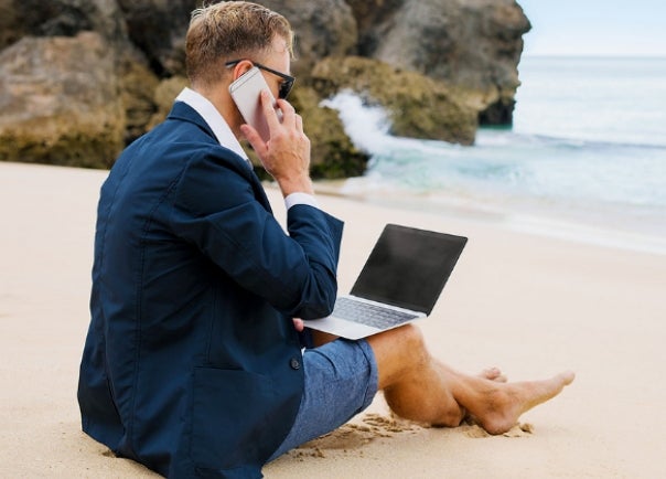 business man with laptop on beach