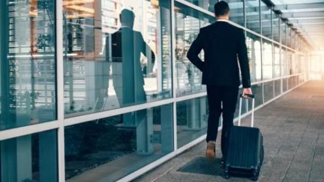 Man pulling a suitcase outside the airport representing duty of care obligations when travelling. 