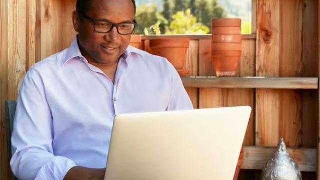 Man working on a laptop, symbolising seamless booking and management solutions from the Airbnb and Flight Centre Travel Group partnership.