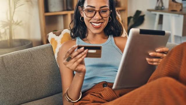 Woman paying with a credit card on her tablet demonstrating credit card travel perks