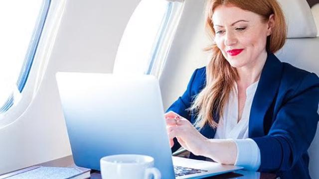 Woman sitting in first class on an airplane representing what’s on offer in Virgin Australia’s and Qantas’ corporate loyalty programs