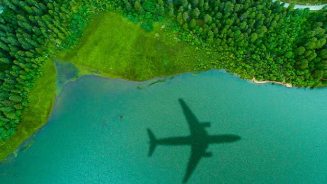 Aerial photograph of a plane demonstrating that businesses adopting sustainable travel and incorporating greener options in their travel policies. 