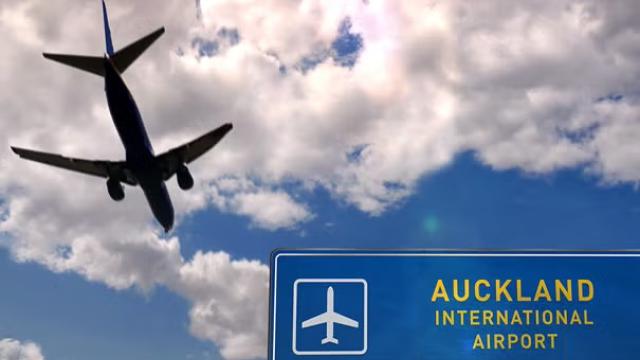Plane flying over Auckland International Airport signage demonstrating the city of Auckland being announced as the number one international business travel destination in 2022