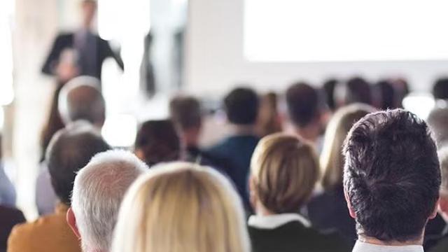 Conference attendees facing the stage representing the Top Conferences to Grow Your Business