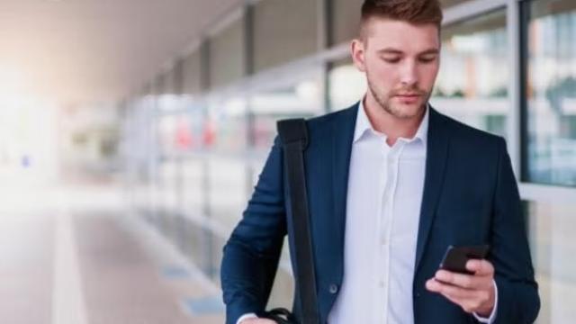 Man walking outside the airport holding a phone representing ways to level up your travellers.