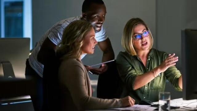 Co-workers looking at a computer screen representing the importance of digital marketing to SMEs. 