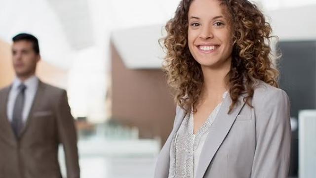 A woman smiling demonstrating how when you need to travel for business, there are a number of variables that can make your trip a productive experience.
