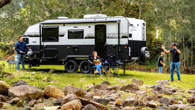 Family playing in a field with a caravan in the background representing how CHQ Group gained financial and logistical control by switching to Corporate Traveller.