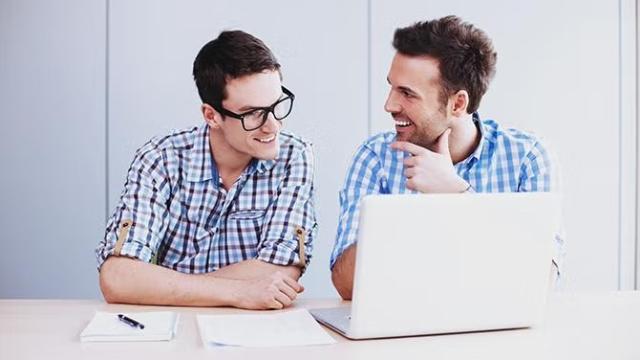 Two co-workers talking excitedly while looking at a laptop demonstrating how making some simple tweaks to its booking processes pulled Diadem out of its last minute booking compulsion.