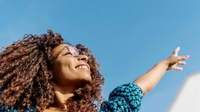 A woman waving here hands in happiness representing Money and stress saving reasons to outsource your business travel.