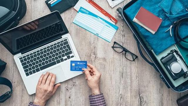 Man using credit card to pay online representing the use of online booking tools for business travel.
