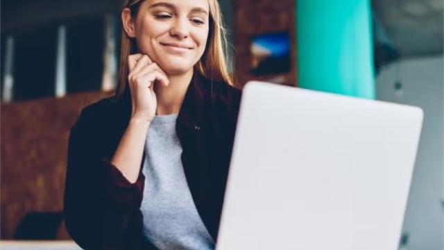 Woman looking at a laptop screen representing the importance of planning your personal and professional development.