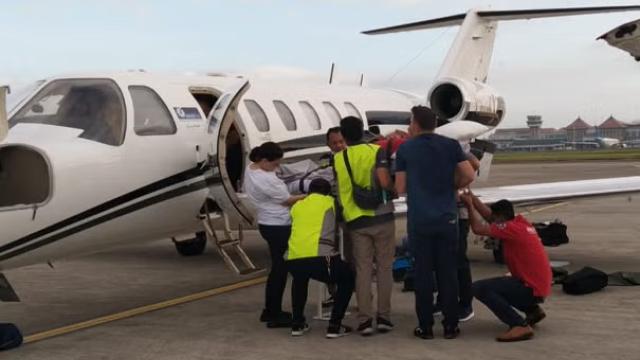 Medical evacuation at the airport with an ambulance and plane in the background representing Southern Cross Assist which supports medical repatriations for several large international insurance companies.