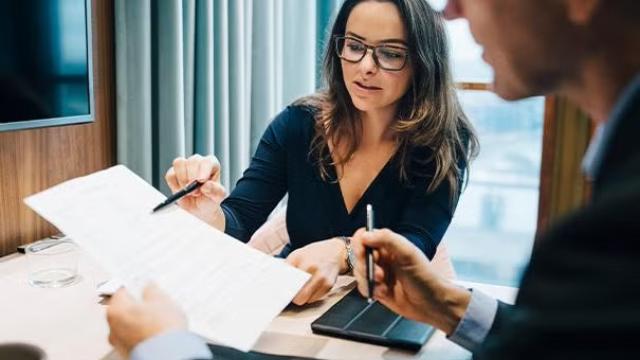 Co-workers reviewing documents representing the importance of consolidating your travel through a single travel management provider.