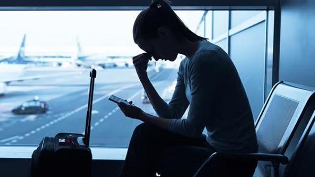 Woman sitting in the airport looking stressed representing Virgin Australia's new Nervous Flyer Program.