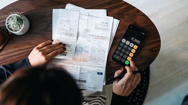 Woman doing paperwork and calculations, highlighting bleisure travel and managing bleisure travel claims.