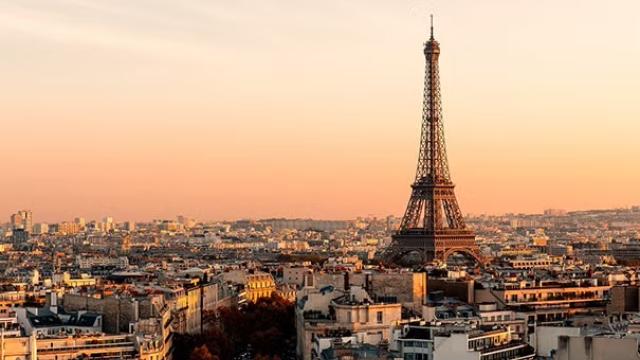 The Eiffel Tower at sunset overlooking Paris, a key destination for corporate travel as businesses plan flights for the upcoming Paris Olympics.