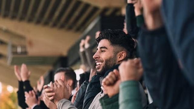 Sports fan at a live game demonstrating that the NRL Grand Final attracts more corporate interest than AFL