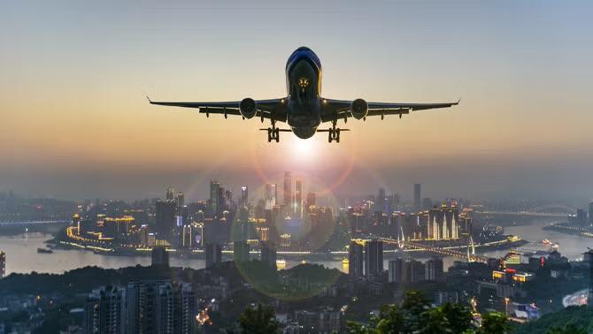 A plane soaring over a cityscape in China, symbolising one of 2023's travel highlights: the reopening of China's borders to international travel