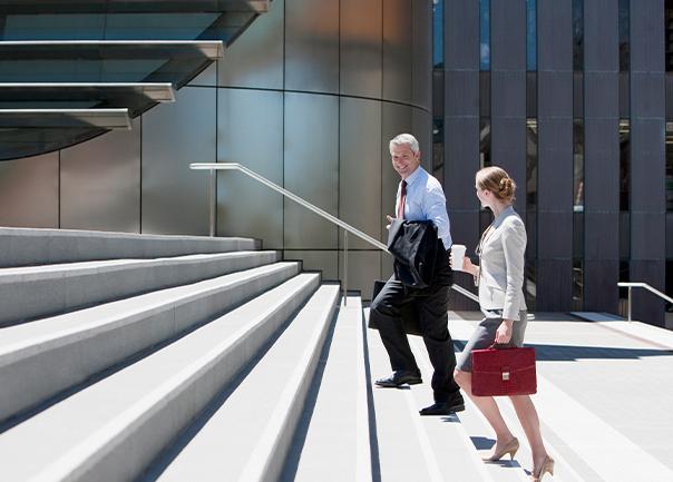 people walking up stairs outside office building