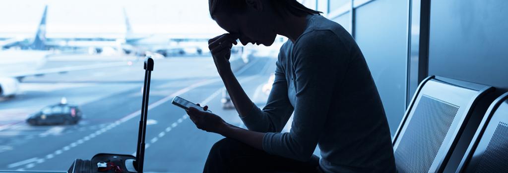 Image of nervous and looking at phone in airport