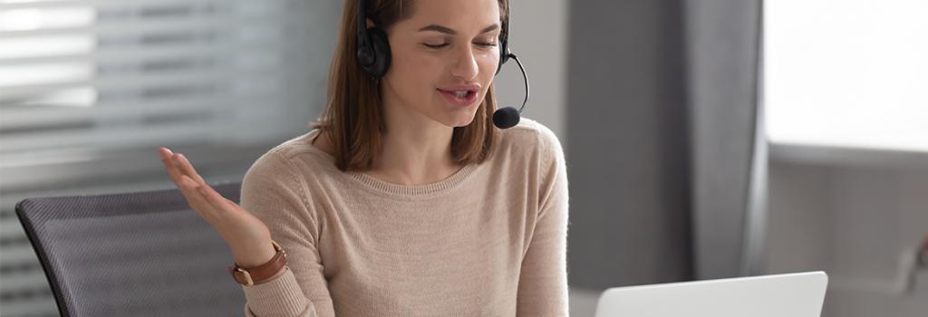 Woman using computer whilst speaking on headset