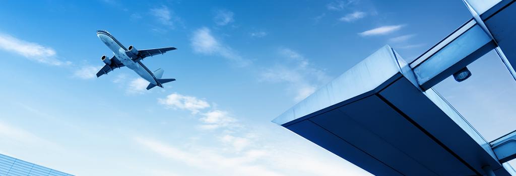 Plane taking off at airport with the terminal in the foreground