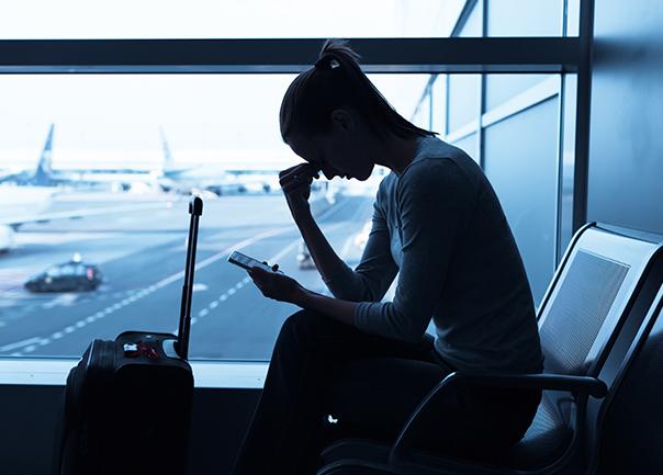 Image of nervous and looking at phone in airport