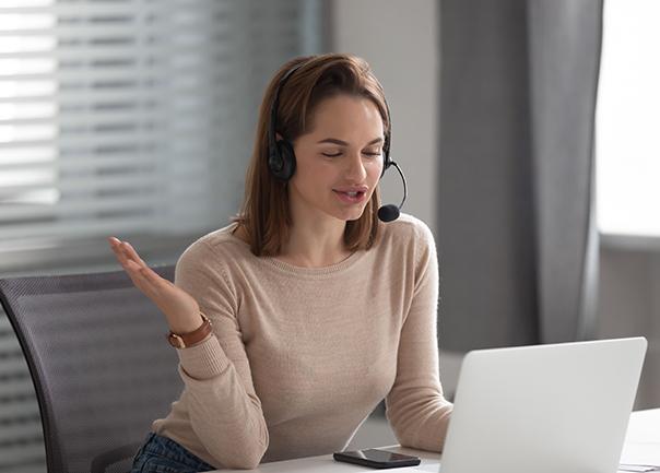 Woman using computer whilst speaking on headset