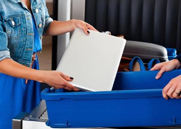 Person placing laptop on security belt