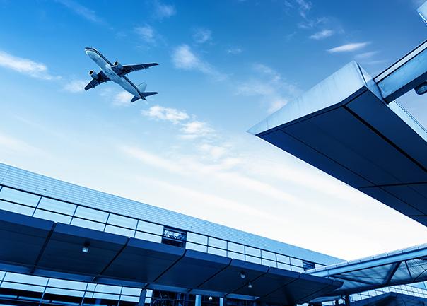 Plane taking off at airport with the terminal in the foreground