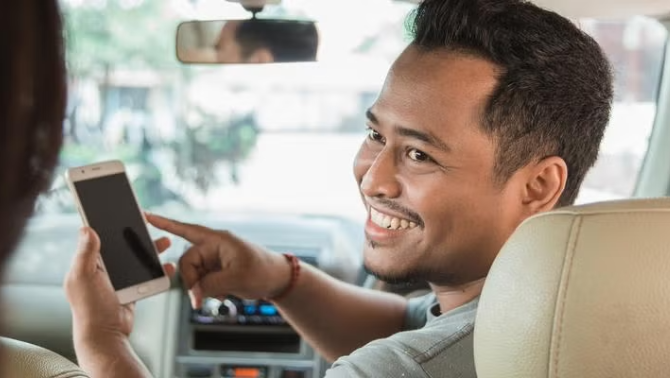 Uber driving talking to a passenger representing the sharing economy.