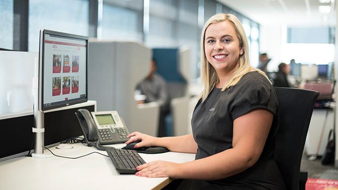 CoT HW - Corporate Traveller Travel Manager at desk with phone and computer