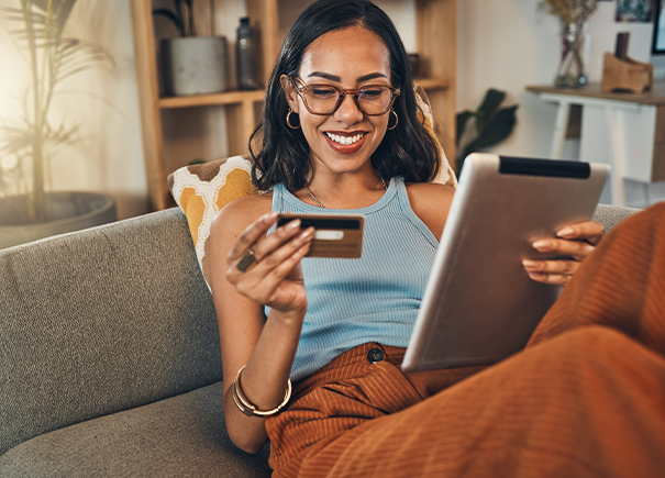 Women looking at credit card and ipad smiling