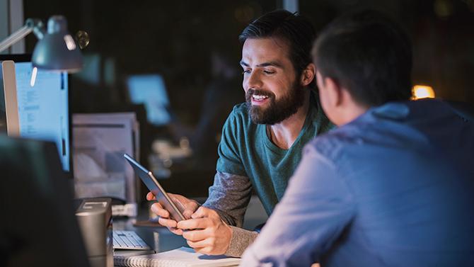 CoT-HW Male professionals looking at tablet surrounded by computres