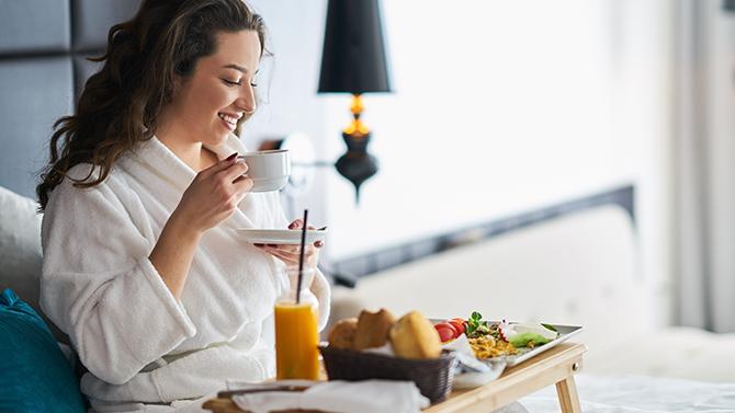 Lady eating breakfast in bed