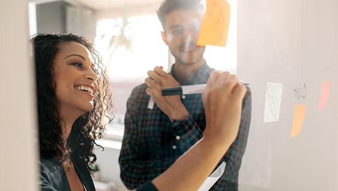 A man and woman talking in the workplace representing travel booker questions asked the most.