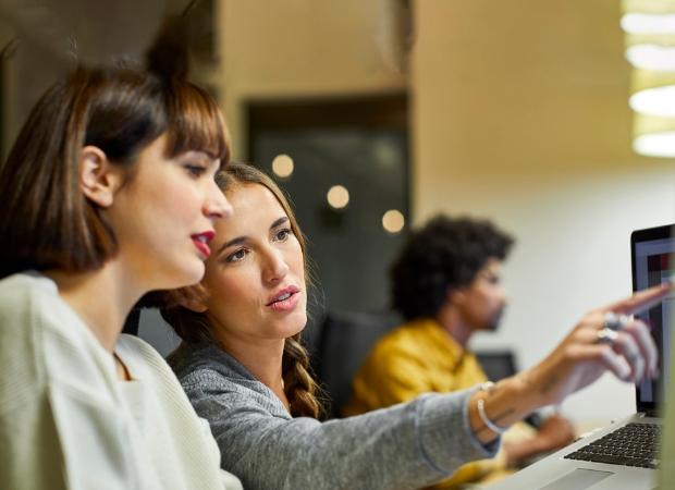 Women looking at computer screen.