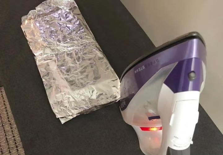 Sandwich wrapped in foil with an iron emonstrating how to survive a hotel quarantine. 