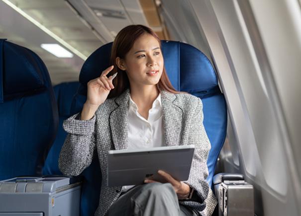 Business woman sitting on an aeroplane and looking out the window.