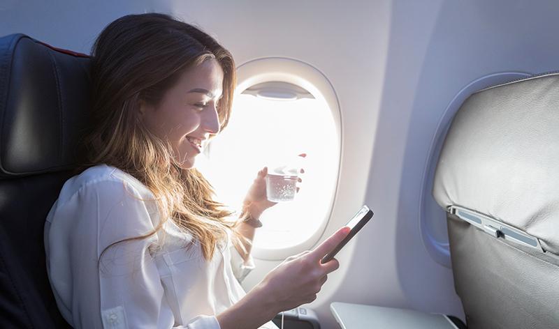 Lady on plane looking at phone