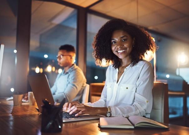 Woman on laptop in office smiling.