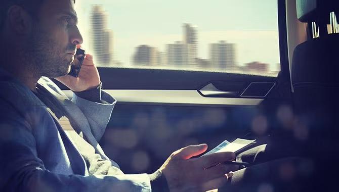 Business traveller speaking on the phone while travelling in a car how Artificial intelligence is rapidly taking hold in the travel industry.