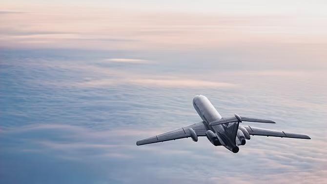 A plane flying over clouds demonstrating the advantages of advance purchase of airfares.