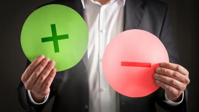 Man holding a plus sign and minus sign representing a guide to AI for SMEs. 