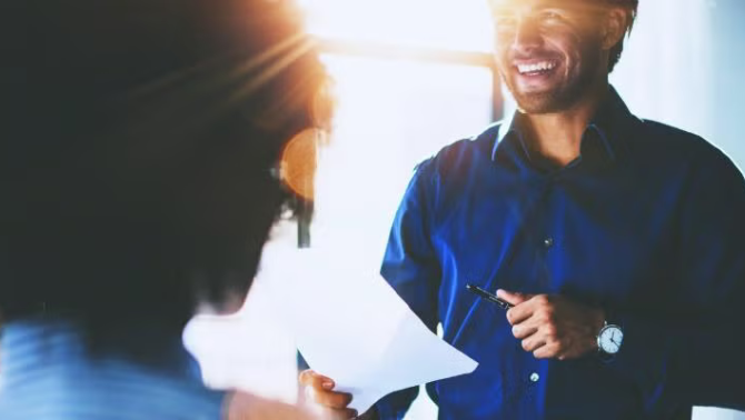 Two co-workers talking excitedly representing how a  travel policy enabled Angus Knight to effectively manage the logistical challenges of travel to remote locations in Australia.
