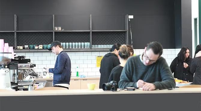 People working in a co-working space, showcasing tourist attractions in the Auckland travel guide. 