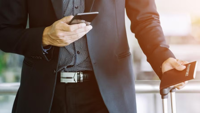Man holding a smartphone and passwords representing business travel industry.