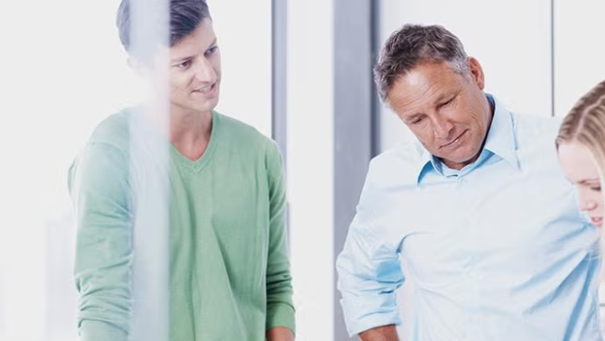 Three co-workers in discussion representing the importance of employee engagement in change management.