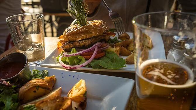 A hamburger sitting on a table, showcasing tourist attractions in the Los Angeles travel guide. 